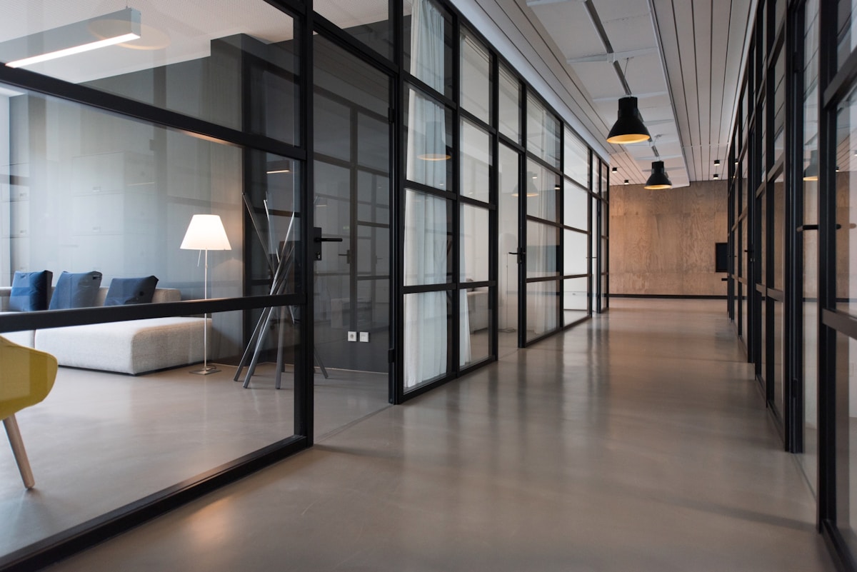 A quiet modern office corridor with meeting rooms.